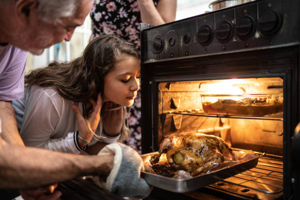 woman smelling chicken in oven